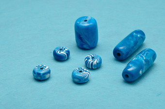 不同的大小蓝色的珠子为Jewelery使孤立的蓝色的背景