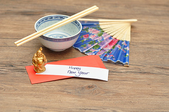中国人新一年设计红色的信封为钱的中国人新一年和请注意快乐新一年与碗筷子手风扇和佛小雕像