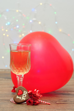 心形状巧克力棒棒糖与的单词爱你玻璃香槟和心形状气球对出焦点光背景