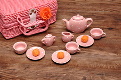 瓷发现了茶集与粉红色的篮子和橙色玫瑰