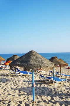 阳伞和太阳便鞋的海滩灯塔岛阿尔加夫葡萄牙