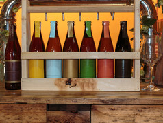 色彩斑斓的啤酒瓶木表格和橙色背景