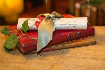 古老的手稿羊皮纸滚动滚与金丝带和红色的书和绿色叶子古老的手稿羊皮纸滚动滚与金ribbo