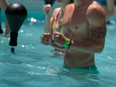 男孩做水有氧运动与拳击速度球户外游泳池男孩做水有氧运动与拳击速度球户外游泳池