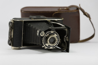 古老的折叠相机与波纹管和棕色（的）皮革情况下古老的折叠相机与波纹管和棕色（的）皮革情况下