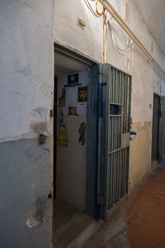 入口黑暗房间监狱细胞与挂报纸剪报的墙入口黑暗房间监狱细胞与挂报纸剪报的墙