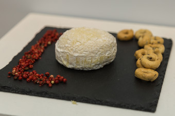 tomino奶酪黑色的桌布装饰与小红色的浆果和tarallitomino奶酪黑色的桌布装饰与小红色的浆果和taralli