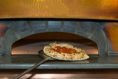 把披萨塞与番茄奶酪成电烤箱把披萨塞与番茄奶酪成电烤箱