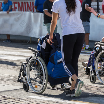 女孩推轮椅与一些背包在城市马拉松女孩推轮椅与一些背包在城市马拉松