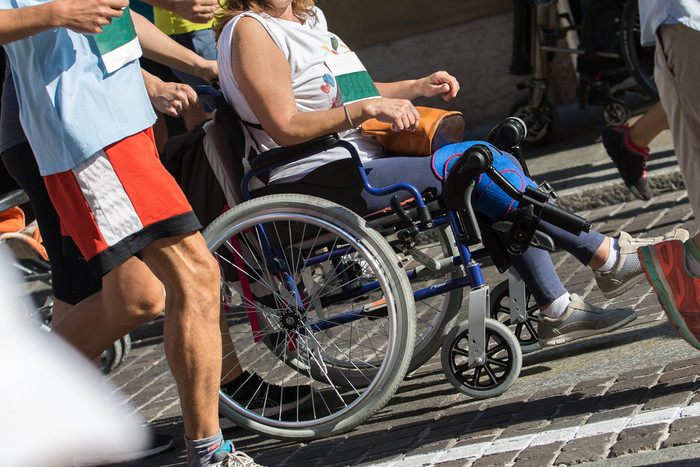 禁用运动员体育运动轮椅在马拉松帮助跑步者禁用运动员体育运动轮椅在马拉松帮助跑步者