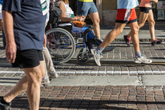 女人与受伤的腿轮椅在马拉松帮助跑步者女人与受伤的腿轮椅在马拉松帮助跑步者