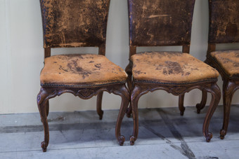 穿棕色（的）古董皮革和木椅子穿棕色（的）古董皮革和木椅子