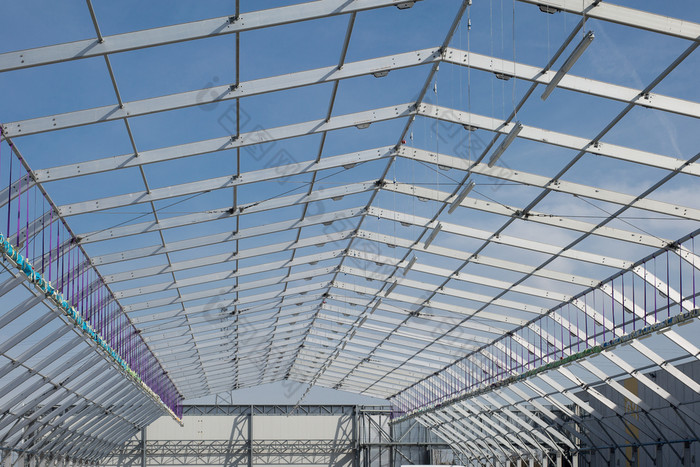 金属天花板结构下建设和蓝色的天空背景金属天花板结构下建设和蓝色的天空背景