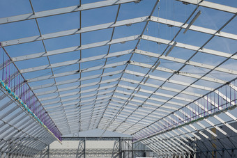 金属天花板结构下建设和蓝色的天空背景金属天花板结构下建设和蓝色的天空背景