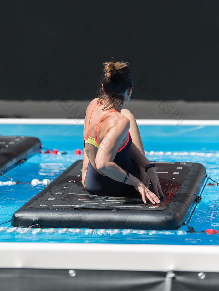 女孩做练习浮动健身席户外游泳池女孩做练习浮动健身席户外游泳池