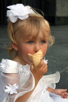 的小女孩白色衣服而且与弓头吃冰淇淋