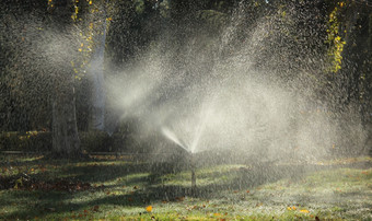 现代设备灌溉花园灌溉系统技术浇水的花园草坪上喷水灭火系统喷涂水在绿色草
