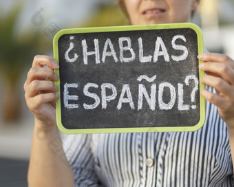 女人持有黑板与的问题以西班牙人你说话西班牙语写西班牙语浅深度场