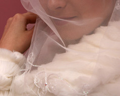 特写镜头的新娘把面纱的脸女人通过白色花边织物