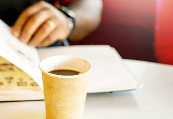 杯子咖啡与黑色的男人。阅读书的背景采取打破与咖啡