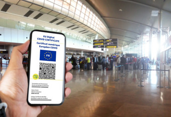 法国数字科维德证书与的代码的屏幕移动举行手与模糊机场的背景翻译从法国欧洲科维德数字证书