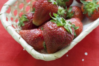 草莓水果说谎柳条篮子的视图从的前特写镜头篮子与成熟的草莓的篮子站红色的餐巾