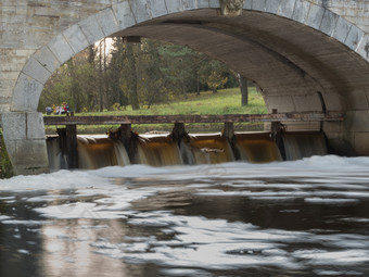 石头拱的桥在的河与光滑的运动水