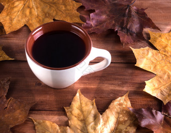 秋天仍然生活杯与茶枫木叶子木表格杯与水果茶和干秋天叶子木背景