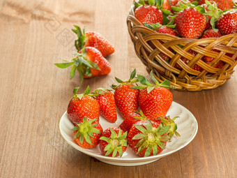 红色的草莓白色板和篮子木表格篮子与新鲜的红色的草莓木表格