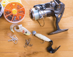 旋转卷spoon-bait摆动器钩子和小轮盒子木背景旋转卷和钓鱼鱼饵木背景