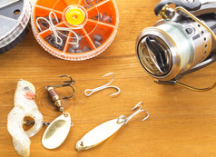 旋转卷spoon-bait摆动器钩子和小轮盒子木背景旋转卷和钓鱼鱼饵木背景