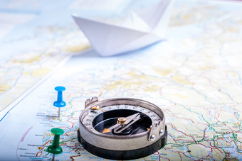 地图挪威与指南针和点标志着路线与纸船的背景指南针地图与标志着路线