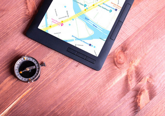 老指南针平板电脑与导航地图的屏幕平板电脑与导航地图和指南针木背景