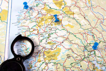 旅游背景与放大镜地图挪威与标志着点目的地地图与放大镜和目的地点