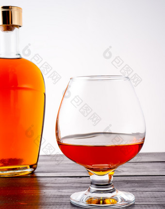 玻璃白兰地的背景完整的瓶与白兰地玻璃白兰地和填满瓶白兰地木背景