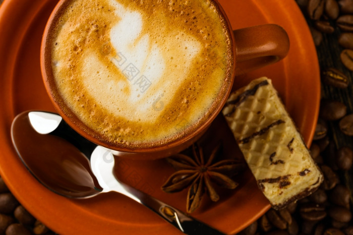 陶瓷杯卡布奇诺咖啡牛奶巧克力晶片而且咖啡豆子木背景