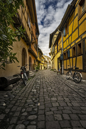 狭窄的街与风景如画的halftimbered房子的中世纪的老小镇eguisheim<strong>阿尔萨斯</strong>地区法国