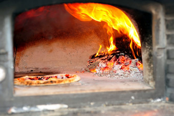 木解雇了披萨烤箱烘焙披萨木燃烧披萨烤箱与发光的煤而且余烬与火焰拍摄