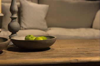 多汁的绿色苹果手工制作的木碗乡村木表格与沙发背景