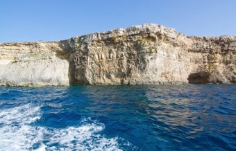 石灰石岩石与洞穴和蓝色的地中海海洋水附近孜然岛马耳他