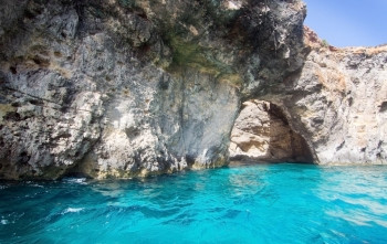 石灰石岩石与洞穴和蓝色的地中海海洋水附近孜然岛马耳他