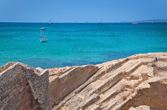 沿海岩石景观和小船绿松石海与地平线阳光明媚的夏天一天马略卡岛西班牙沿海岩石景观和小船绿松石海