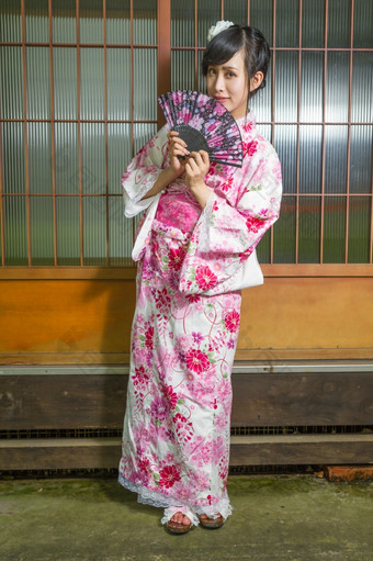 亚洲女人穿和服前面<strong>日本房子</strong>持有风扇