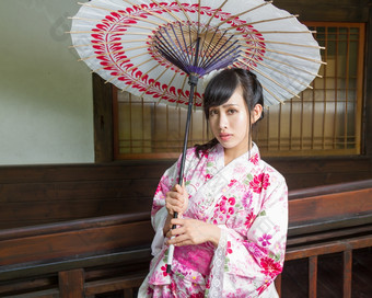 亚洲女人穿和服前面<strong>日本房子</strong>持有伞