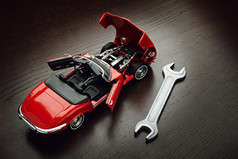 概念修复维护和维修机器模型红色的蓬式汽车与打开门和罩和扳手木表面