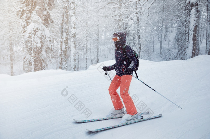 年轻的女滑雪滑动下来的坡下降雪