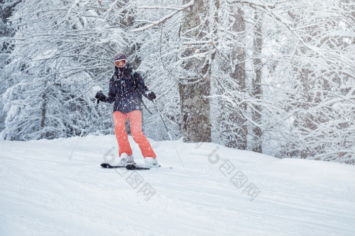 年轻的女滑雪滑动下来的坡下降雪