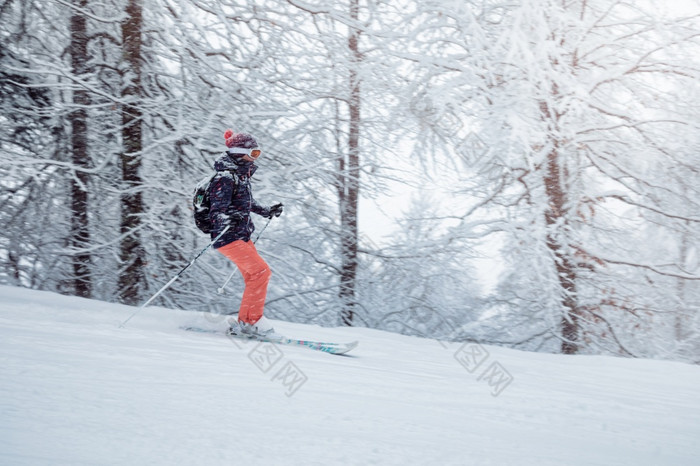 年轻的女滑雪滑动下来的坡下降雪