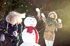 雪球战斗年轻的女人扔雪球焦点运动模糊