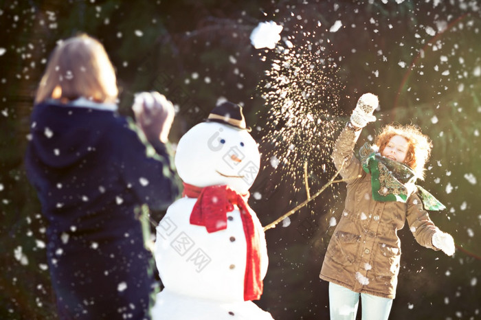 两个女孩有雪球战斗一个他们扔雪球焦点运动模糊